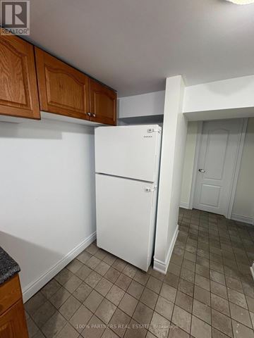 Newmarket (Bristol-London) apartment for rent - A white refrigerator in a kitchen with wooden cabinets.