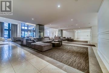 Toronto (Islington-City Centre West) condo for rent - A spacious living room with a large sectional sofa and a rug in the center.