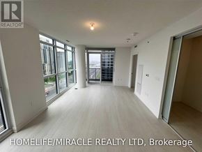 Toronto (Islington-City Centre West) condo for rent - A spacious room with a view of the city through large windows.
