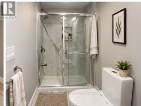 Brampton (Fletcher's West) apartment for rent - A bathroom with a glass shower door and a toilet.