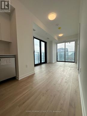 Kitchener condo for rent - A spacious kitchen with wooden flooring and a refrigerator.