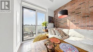Toronto (Waterfront Communities) condo for rent - A living room with a white couch and a brick wall.