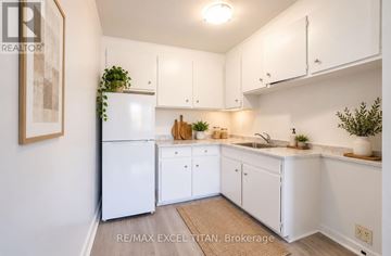 Oshawa (Lakeview) condo for rent - A white kitchen with a fridge, cabinets and a sink.