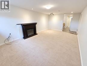 Burnaby apartment for rent - A living room with a fireplace and carpeted floor.