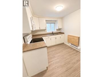 Burnaby apartment for rent - A kitchen with white cabinets and a wooden floor.