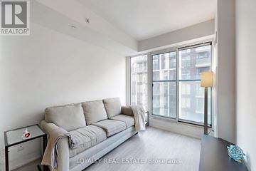Toronto (Moss Park) condo for rent - A living room with a grey couch and a glass table.