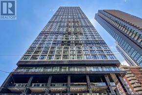 Toronto (Moss Park) condo for rent - A tall building with the words "Loyalty Real Estate, Brokerage" on the lower floors.