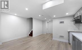 Brampton (Madoc) apartment for rent - A spacious room with wooden flooring and white walls.
