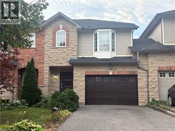 Hamilton townhouse for rent - A house with a garage and a driveway in front.