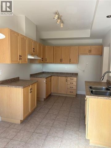Hamilton townhouse for rent - A kitchen with wooden cabinets and a sink.
