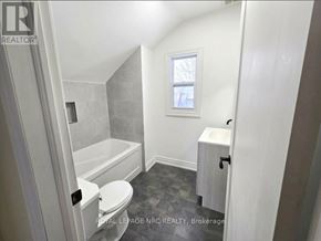 Port Colborne (East Village) fourplex for rent - A white bathroom with a tub, toilet and sink.