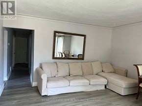 Toronto (Woburn) apartment for rent - A white couch sits in a room with a mirror above it.
