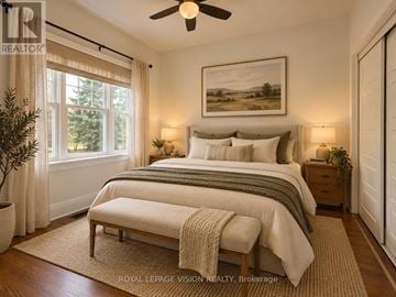 Oshawa (O'neill) apartment for rent - A bedroom with a large bed and a ceiling fan.