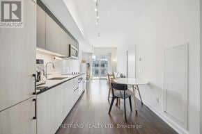 Toronto (South Riverdale) condo for rent - A modern kitchen with a dining table and chairs in the middle of the room.