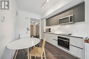 Toronto (South Riverdale) condo for rent - A modern kitchen with a white table and a microwave above it.