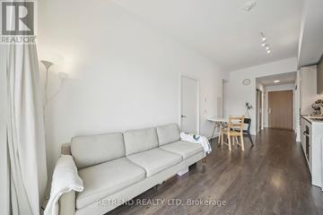 Toronto (South Riverdale) condo for rent - A living room with a white couch and wooden floors.