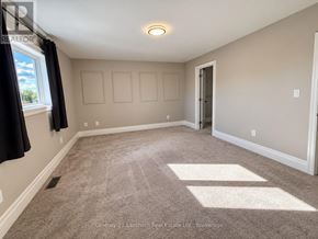 Prince Edward County (Picton Ward) townhouse for rent - A room with a carpeted floor and a window with curtains.