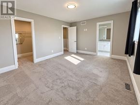 Prince Edward County (Picton Ward) townhouse for rent - A spacious room with a carpeted floor and white walls.