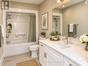 Prince Edward County (Picton Ward) townhouse for rent - A white bathroom with a marble counter top and a white toilet.