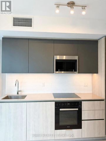 Toronto (Waterfront Communities) condo for rent - A modern kitchen with a stainless steel oven and white cabinets.