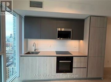 Toronto (Waterfront Communities) condo for rent - A modern kitchen with a view of the city.