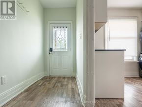 St. Catharines (E. Chester) apartment for rent - A white door with a stained glass window is in a room with wooden floors.