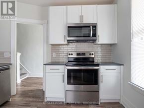 St. Catharines (E. Chester) apartment for rent - A modern kitchen with white cabinets and stainless steel appliances.