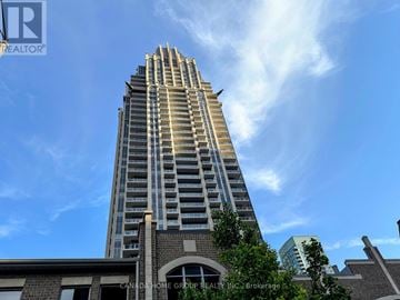 Mississauga (City Centre) condo for rent - A tall building with a clear blue sky in the background.