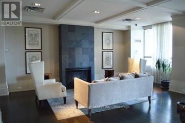 Mississauga (City Centre) condo for rent - A living room with a grey couch and a fireplace.
