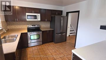 Toronto (Mount Olive-Silverstone-Jamestown) apartment for rent - A kitchen with brown cabinets and a stove top oven.