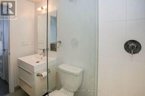 Toronto (Kensington-Chinatown) condo for rent - A white bathroom with a toilet, sink, and mirror.