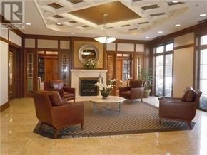 Toronto (Willowdale East) condo for rent - A living room with a fireplace and brown leather chairs.
