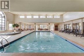 Toronto (Willowdale East) condo for rent - A large indoor swimming pool with lounge chairs and a plant.