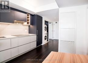 Toronto (Church-Yonge Corridor) condo for rent - A modern kitchen with dark wood floors and white cabinetry.