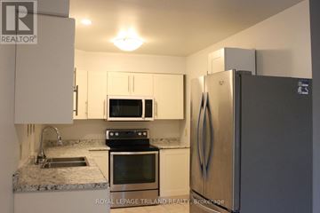 London North (North C) townhouse for rent - A kitchen with a refrigerator, microwave, oven, and sink.