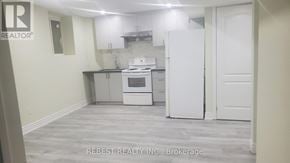 Brampton (Northwest Sandalwood Parkway) apartment for rent - A kitchen with a white fridge and oven, and a white door.