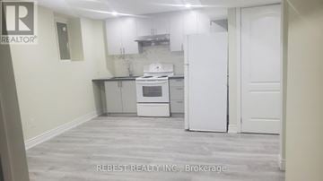 Brampton (Northwest Sandalwood Parkway) apartment for rent - A kitchen with a white fridge and oven, and a white door.