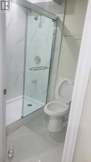 Brampton (Northwest Sandalwood Parkway) apartment for rent - A white toilet in a glass shower stall.