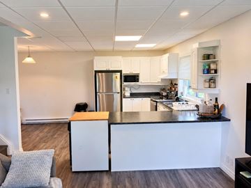 Gatineau (Gatineau) condo for rent - A kitchen with white cabinets and a black countertop.