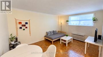 Toronto (Stonegate-Queensway) multi-family for rent - A living room with a couch, chair, and table.