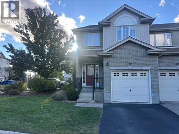 Kitchener townhouse for rent - A house with a garage and a tree in front.