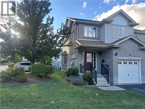 Kitchener townhouse for rent - A house with a grey garage door and a red door.