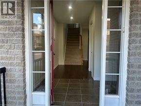 Kitchener townhouse for rent - A hallway with a red door and a sign that says REALTOR.