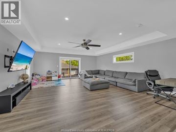 Tecumseh apartment for rent - A living room with a grey sofa and a television on the wall.
