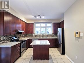Markham (Wismer) apartment for rent - A kitchen with dark wood cabinets and granite countertops.