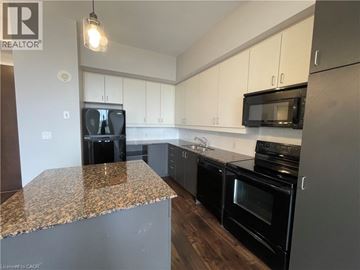 Waterloo condo for rent - A kitchen with black appliances and a granite countertop.