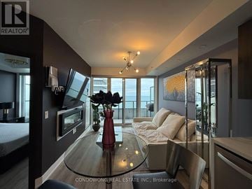 Toronto (Mimico) condo for rent - A modern living room with a glass table and a view of the city.