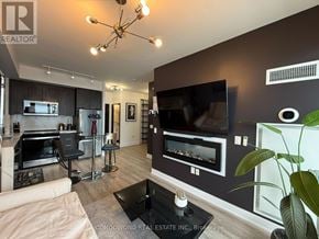 Toronto (Mimico) condo for rent - A modern living room with a large TV and a bar area.