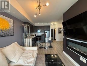 Toronto (Mimico) condo for rent - A modern living room with a large painting on the wall and a flat screen TV.