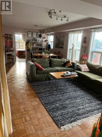Toronto (Palmerston-Little Italy) multi-family for rent - A living room with a green couch and a coffee table.